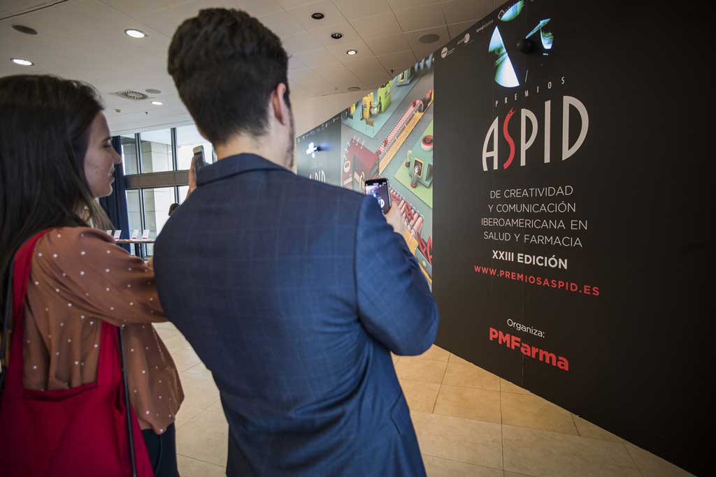 Asistentes fotografiando el photocall de la sala de exposición