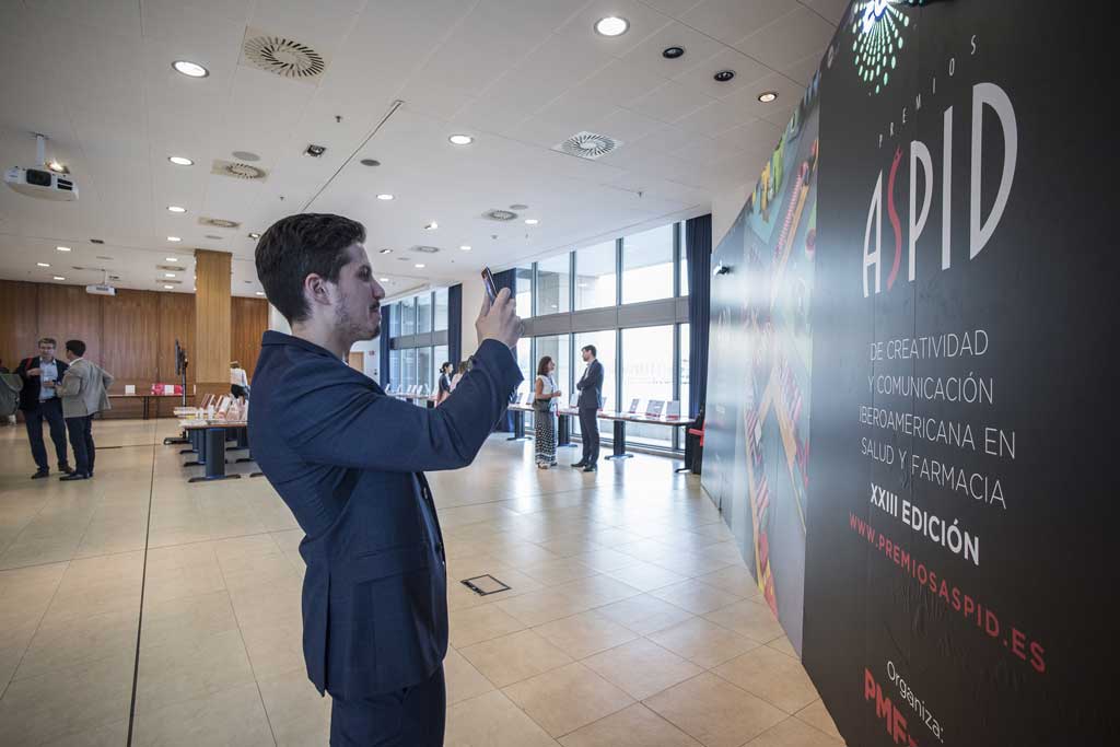 Asistentes fotografiando el photocall de la sala de exposición