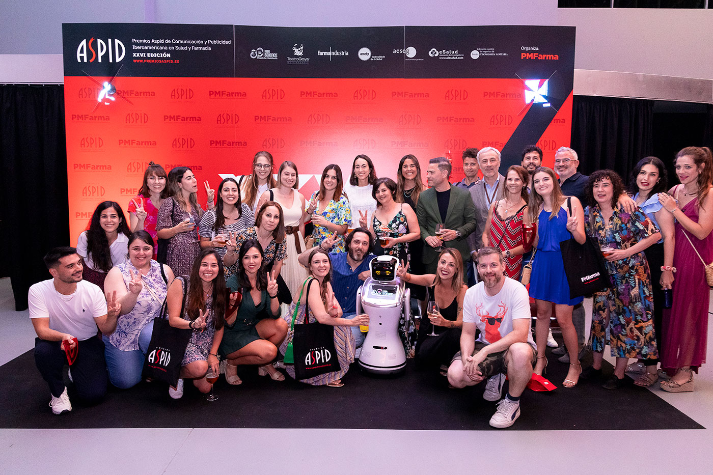 Los invitados posando en el photocall con la robot Jimena y los kits de bienvenida
