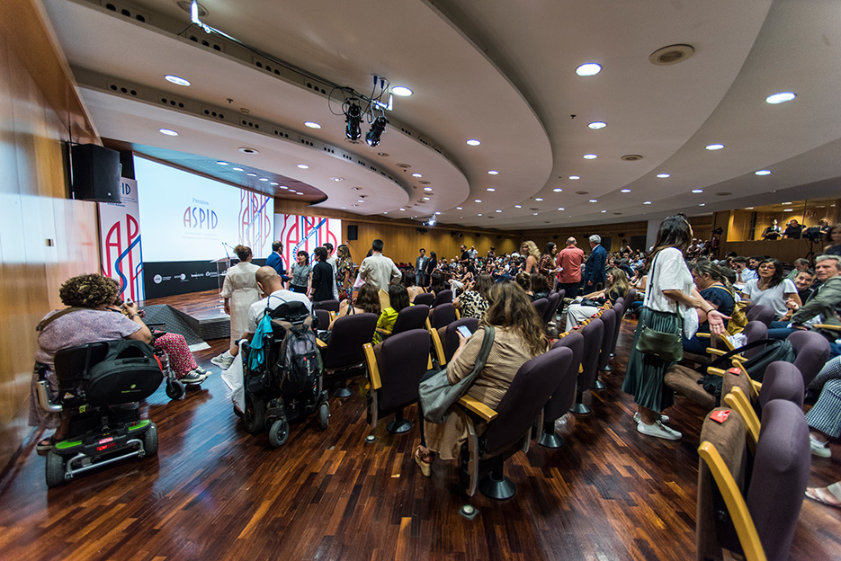 Asistentes y presentadores buscando su lugar en el auditorio